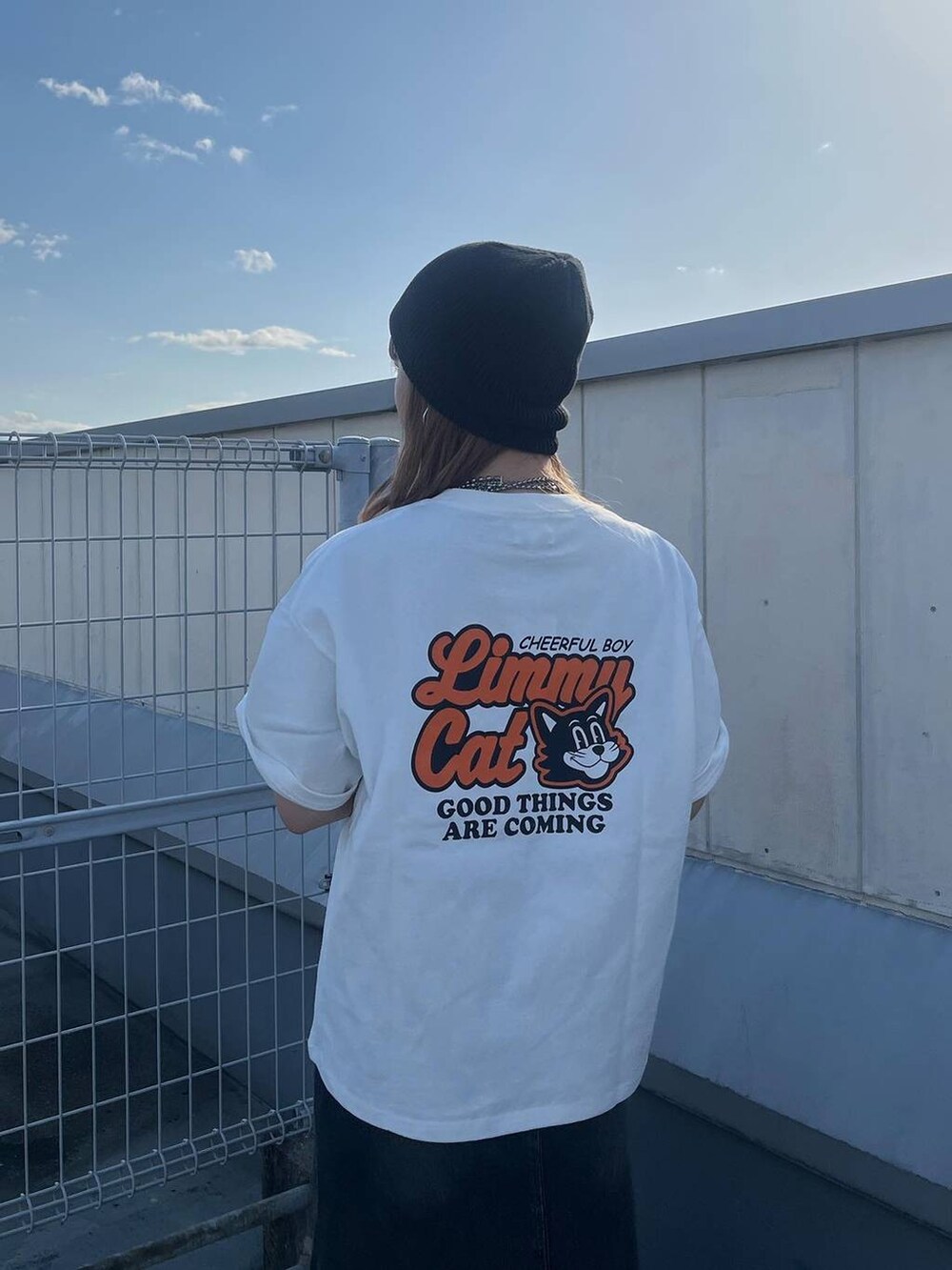 ブラック系のブーツ、ブラック系のデニムスカート、ホワイト系のTシャツ/カットソーを着用したレディースの春コーディネートの4枚目の写真