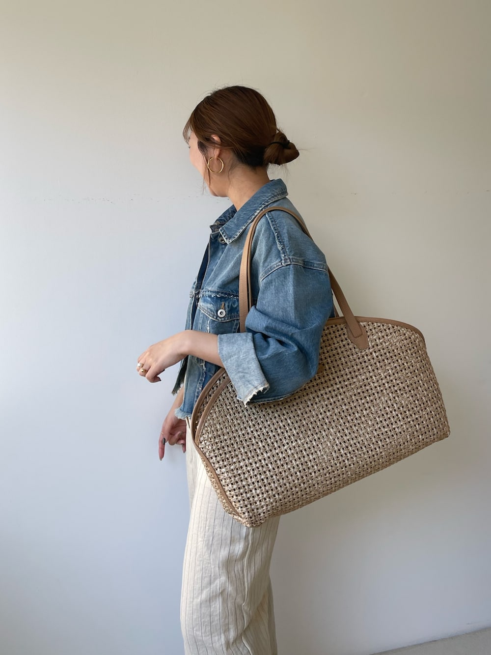 イエロー系のトートバッグを着用したレディースの冬コーディネートの2枚目の写真