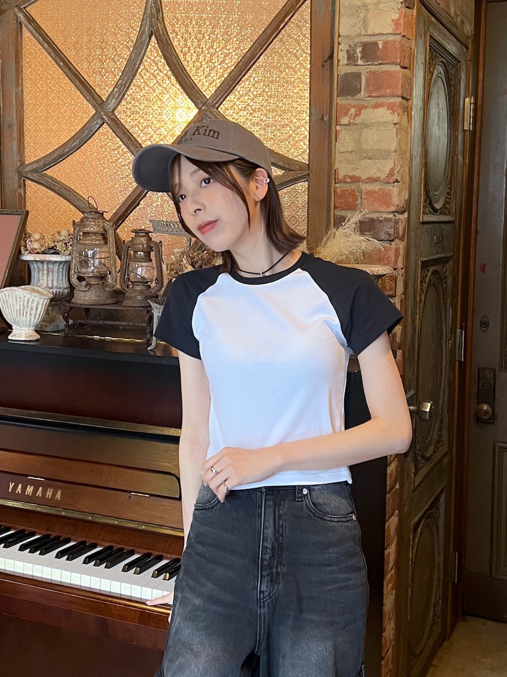 ブラック系のスニーカー、ブラック系のデニムパンツ、ホワイト系のTシャツ/カットソーを着用したレディースの夏コーディネートの3枚目の写真