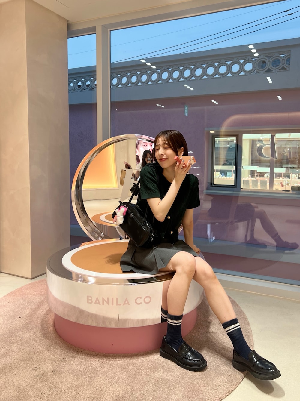 グレー系のスカート、グリーン系のカーディガン/ボレロ、ブラック系のローファーを着用したレディースの夏コーディネートの3枚目の写真