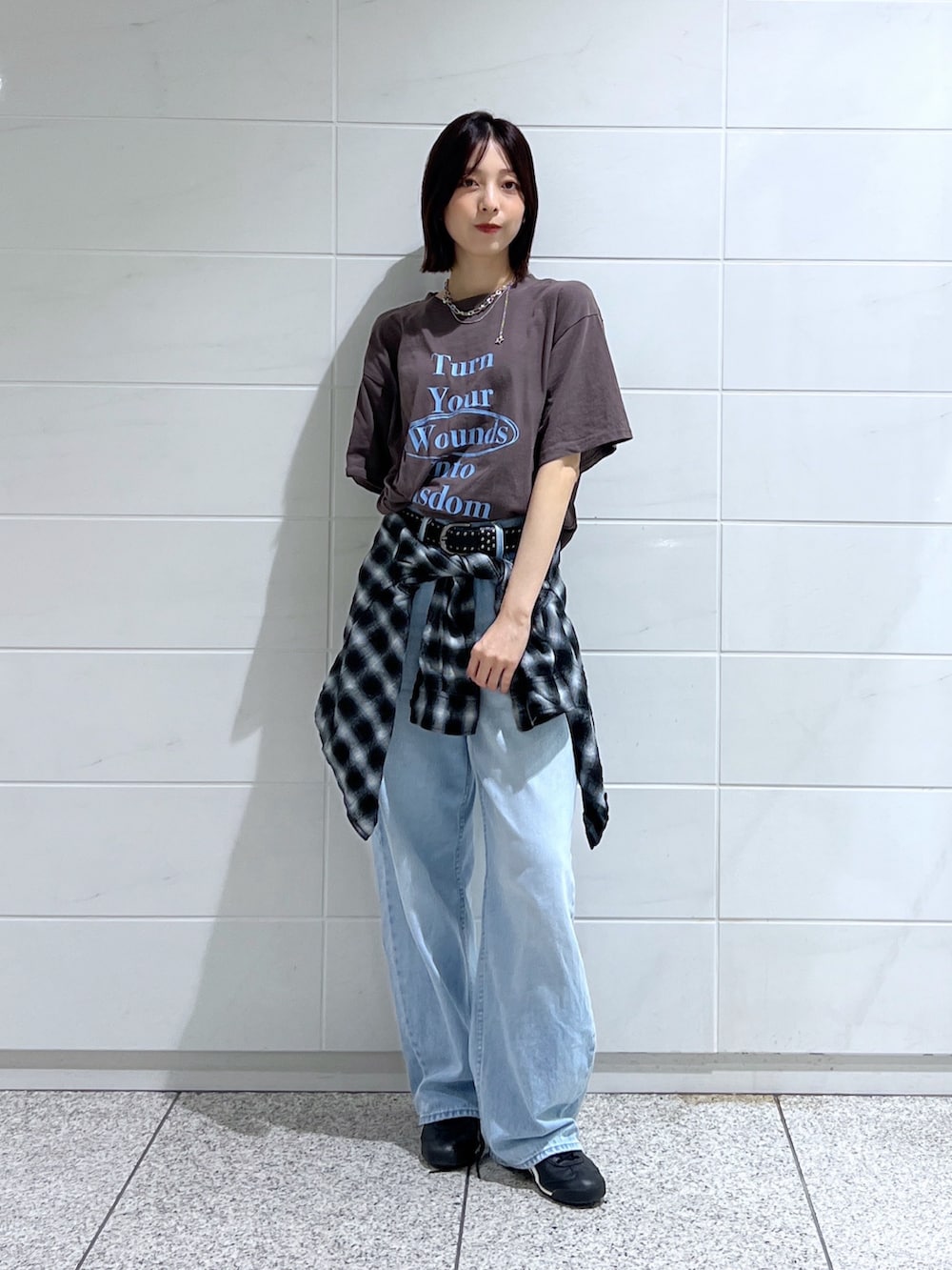 ブラウン系のTシャツ/カットソー、ブラック系のスニーカー、ブラック系のベルトを着用したレディースの秋コーディネートの2枚目の写真