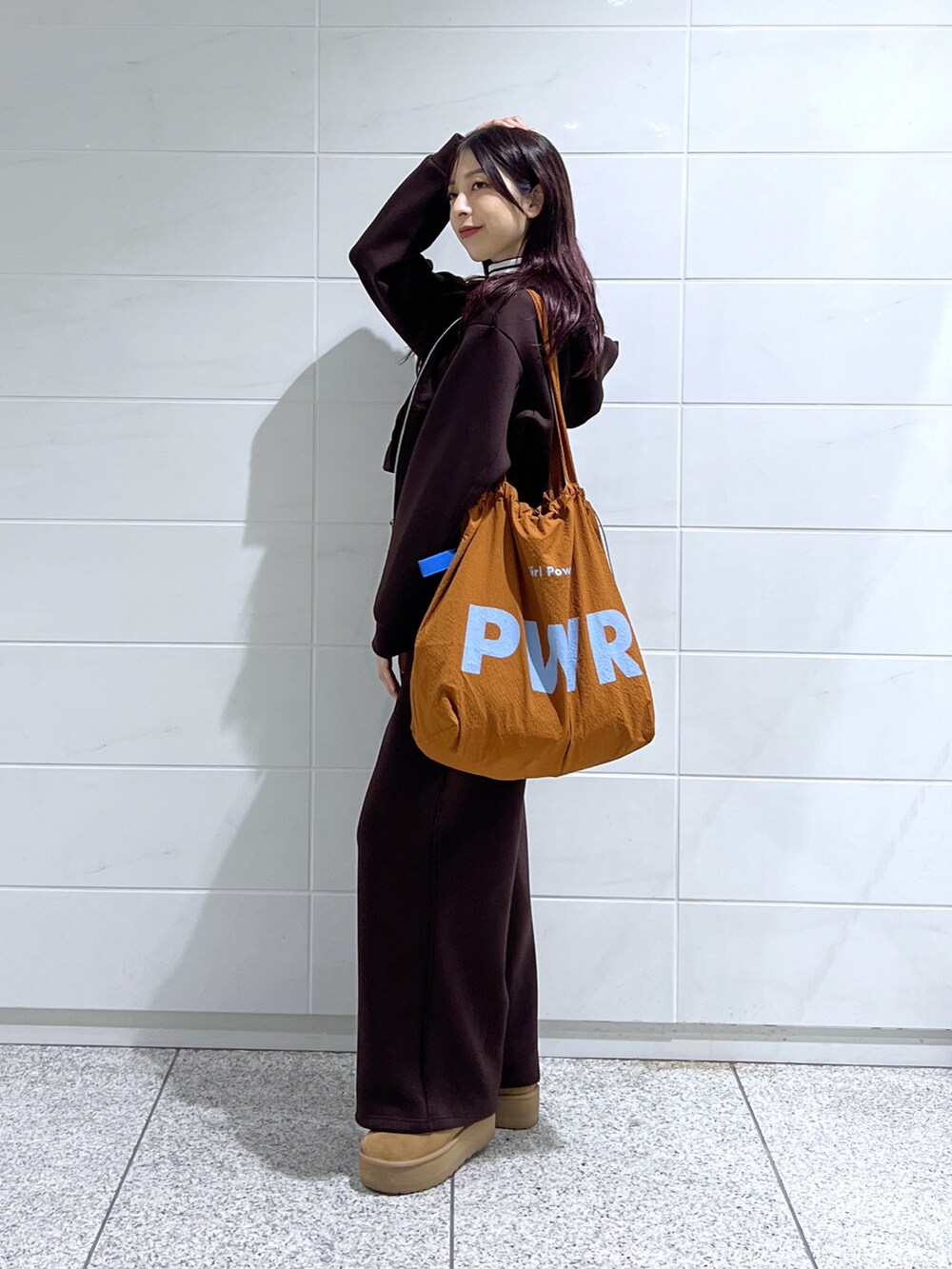 ホワイト系のTシャツ/カットソー、ブラウン系のトートバッグ、ブラウン系のブーツを着用したレディースの秋コーディネートの3枚目の写真