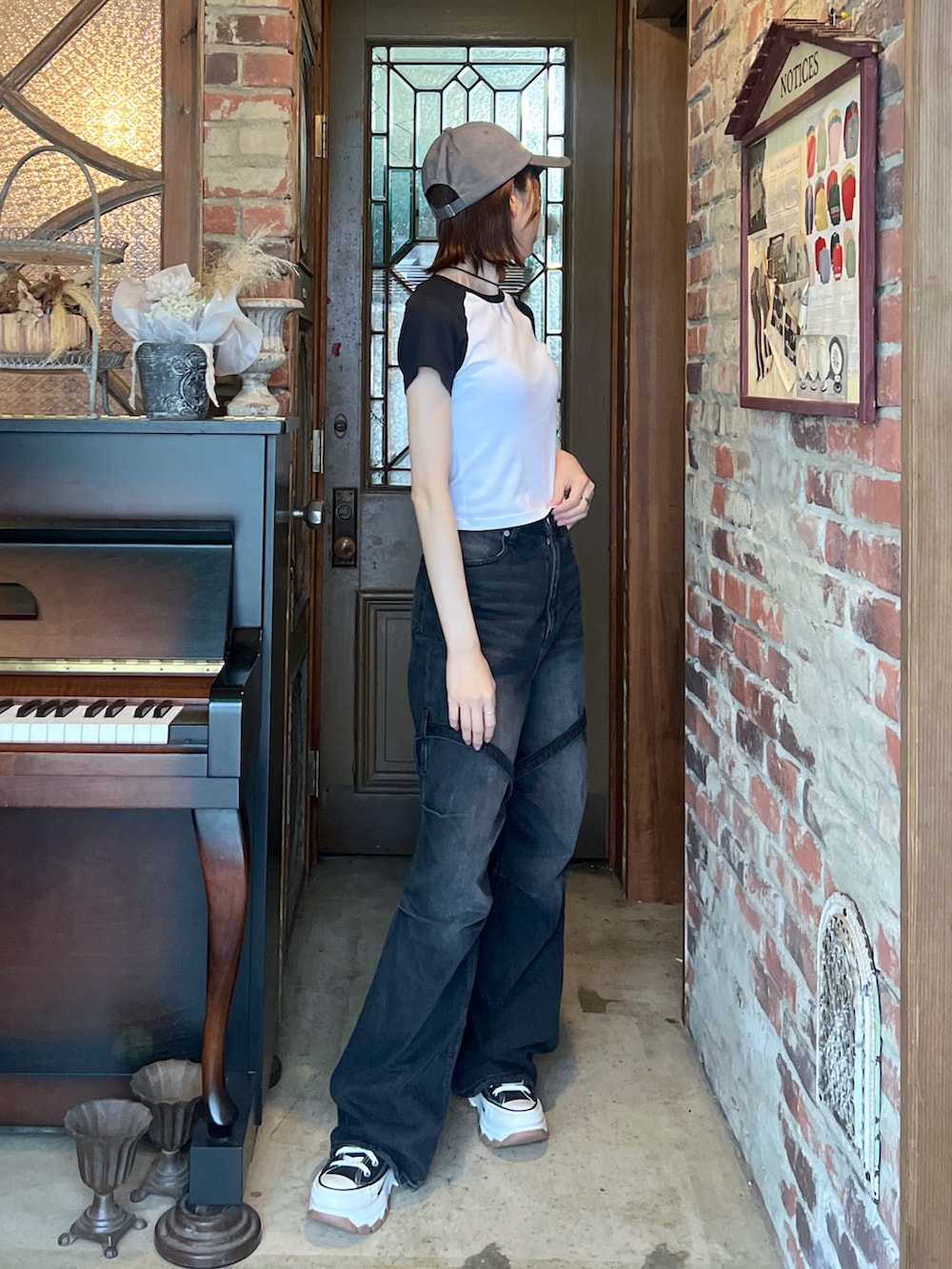 ブラック系のスニーカー、ブラック系のデニムパンツ、ホワイト系のTシャツ/カットソーを着用したレディースの夏コーディネートの2枚目の写真
