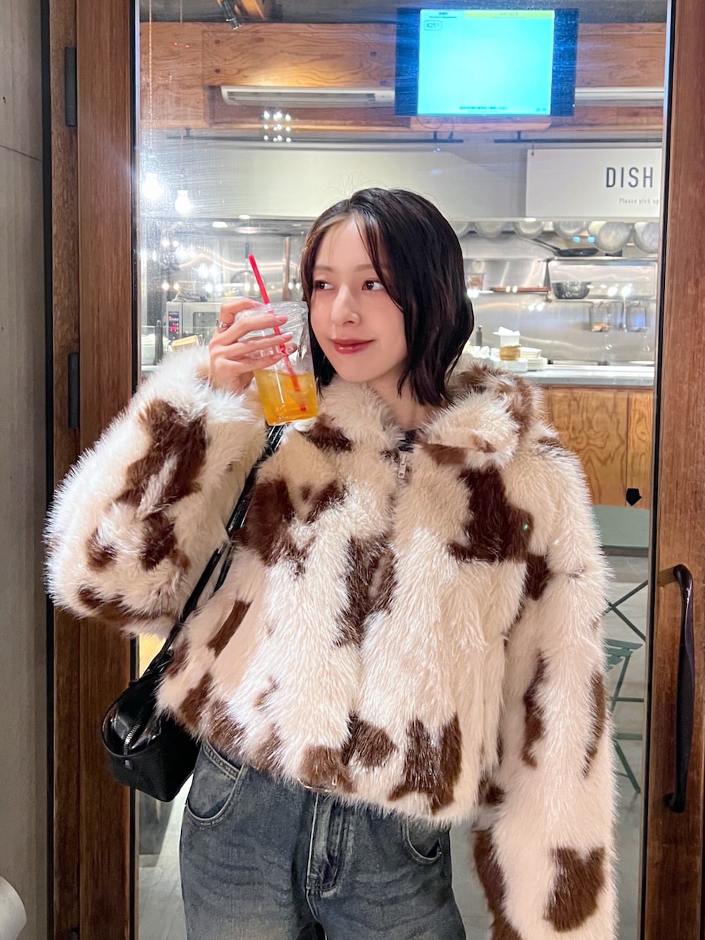 その他のデニムパンツ、ブラウン系のブーツ、ベージュ系のその他アウターを着用したレディースの冬コーディネートの2枚目の写真