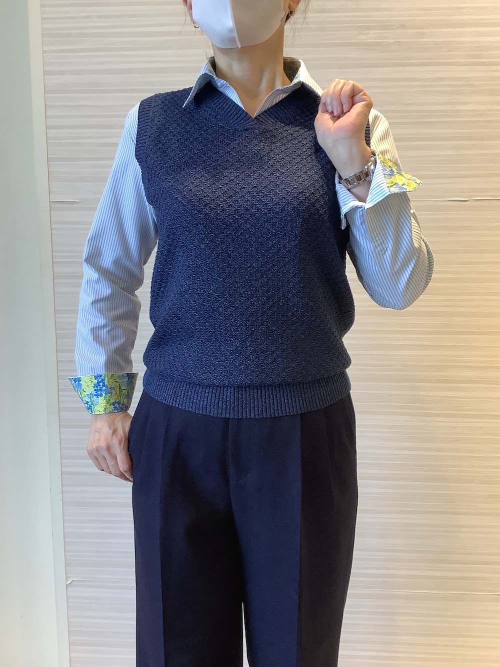 ブルー系のベスト、グリーン系のビジネスシャツを着用したレディースの冬コーディネートの2枚目の写真