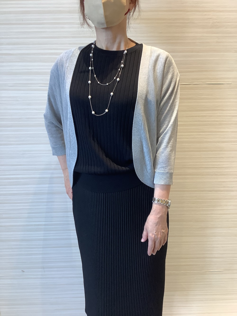 ブラック系のニット/セーター、グレー系のカーディガン/ボレロを着用したレディースの夏コーディネートの2枚目の写真