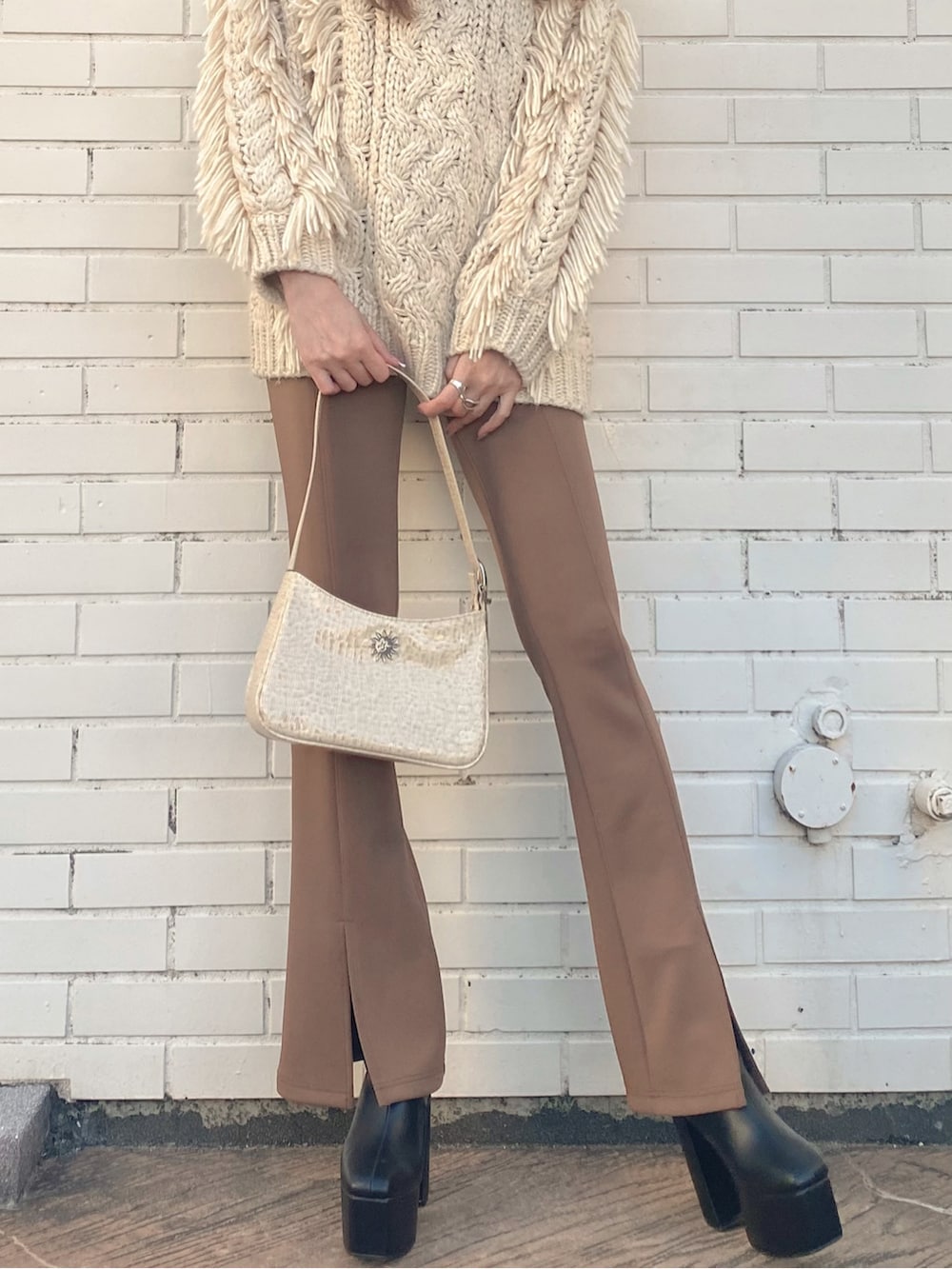 ホワイト系のショルダーバッグ、ブラウン系のレギンス/スパッツを着用したレディースの冬コーディネートの3枚目の写真