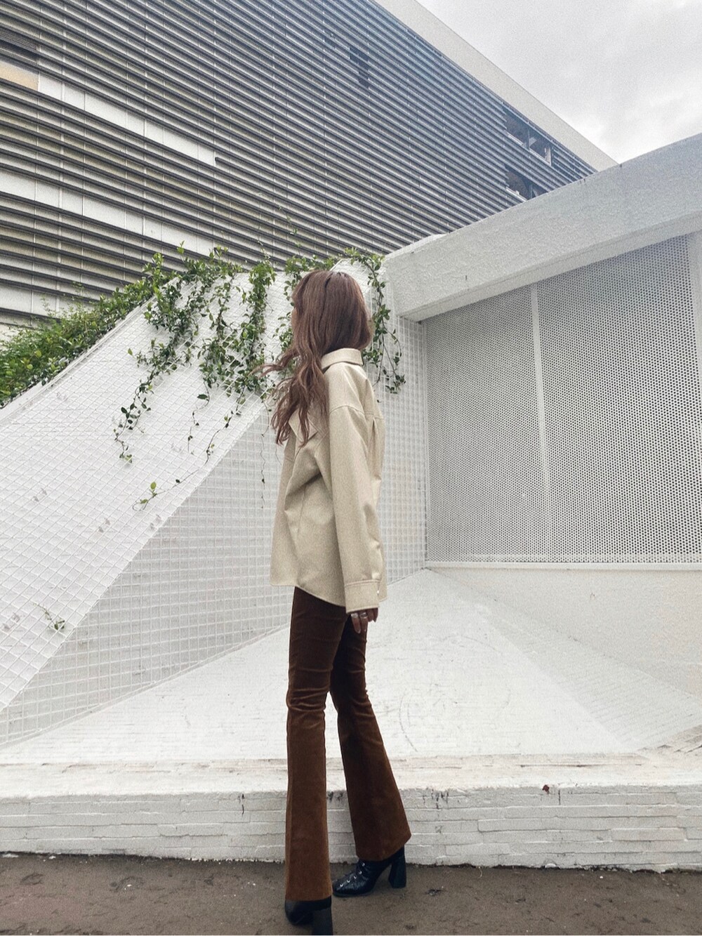 ブラウン系のその他パンツ、ブラック系のブーツを着用したレディースの秋コーディネートの2枚目の写真