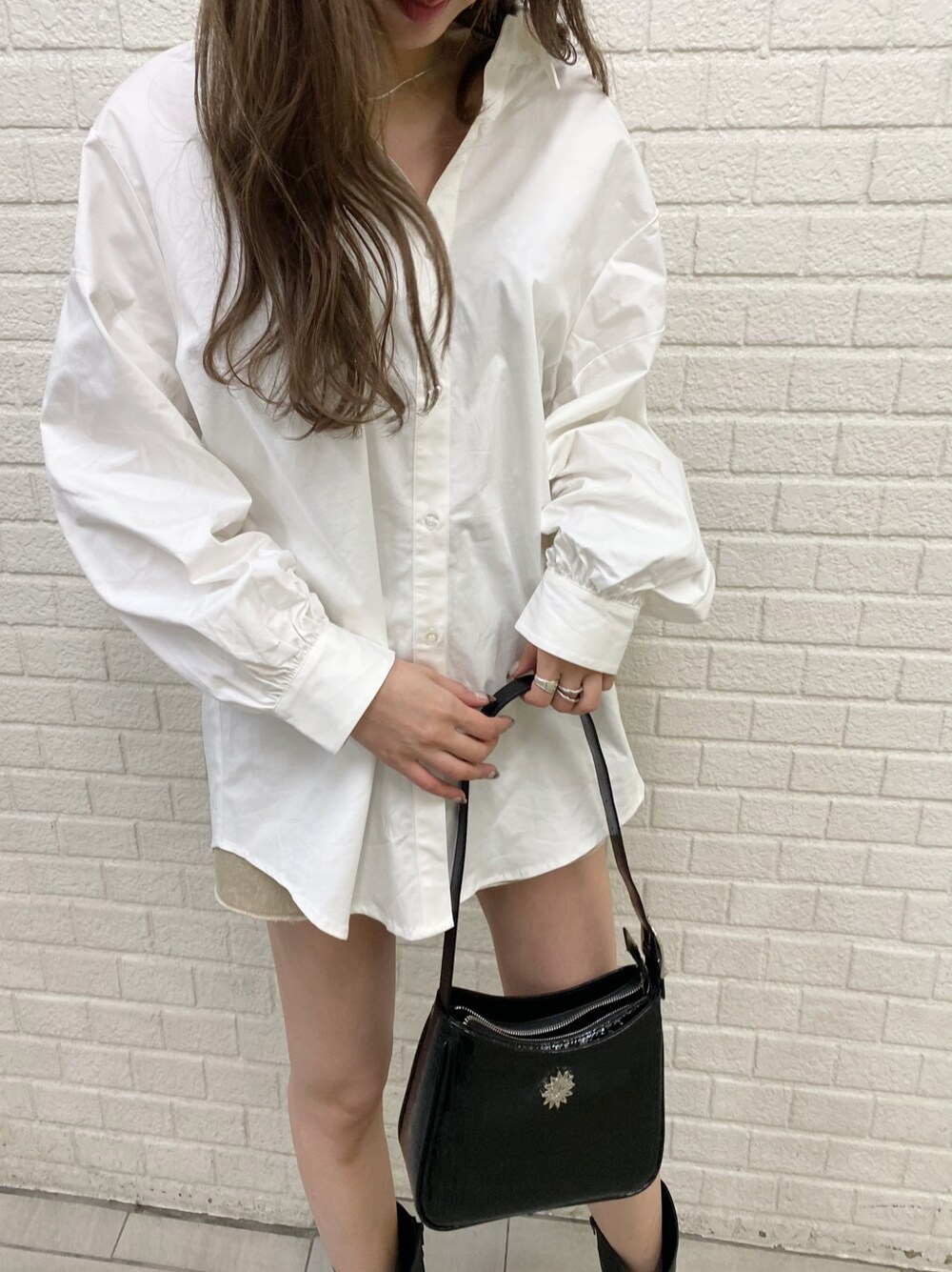 ベージュ系のデニムスカート、ブラック系のブーツ、ホワイト系のシャツ/ブラウスを着用したレディースの冬コーディネートの4枚目の写真