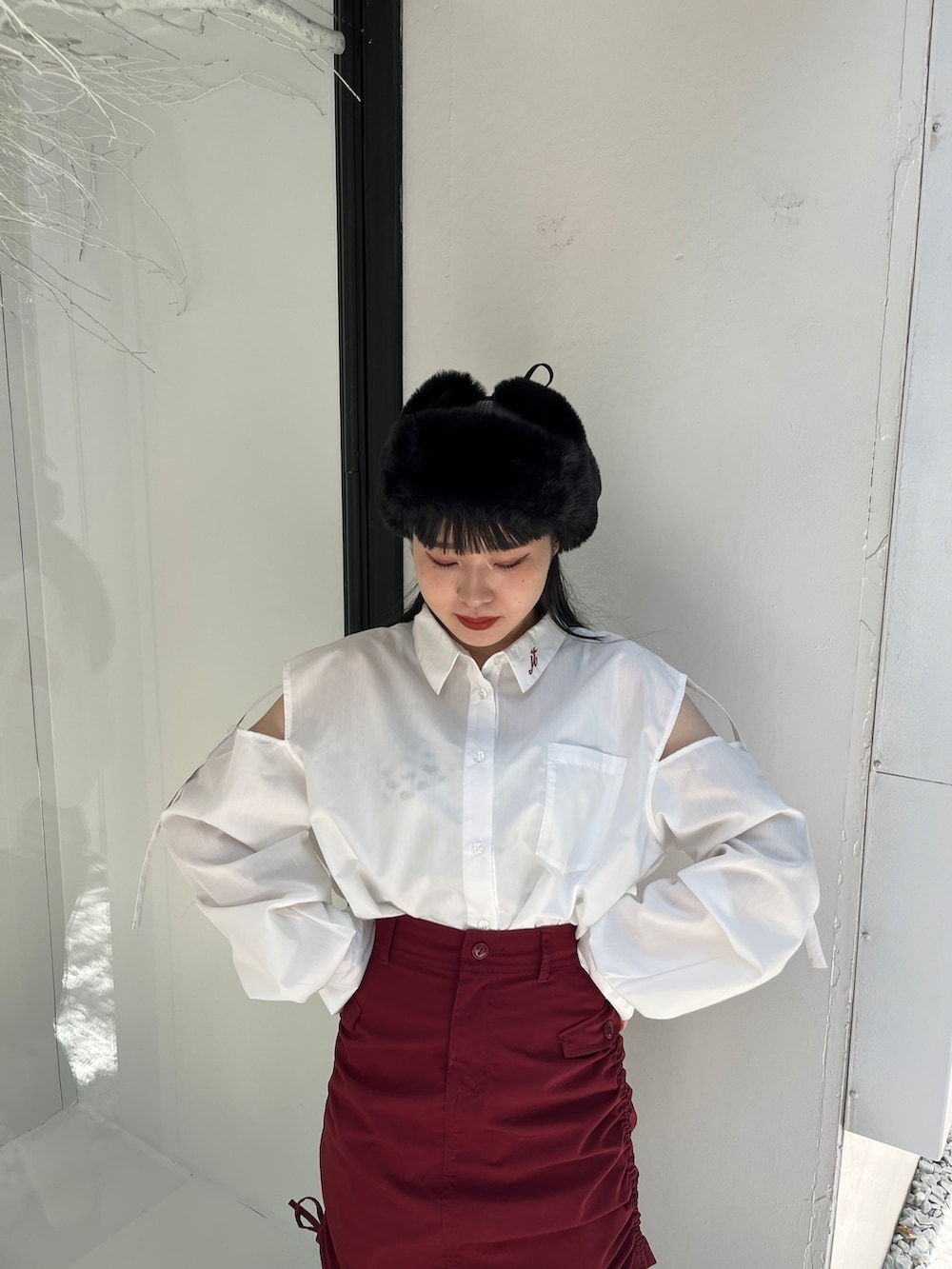 レッド系のスカート、ホワイト系のシャツ/ブラウス、ブラック系のキャップを着用したレディースの夏コーディネートの4枚目の写真