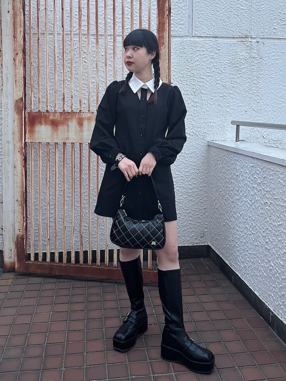 ブラック系のワンピース、ブラック系のブーツを着用したレディースの冬コーディネートの2枚目の写真