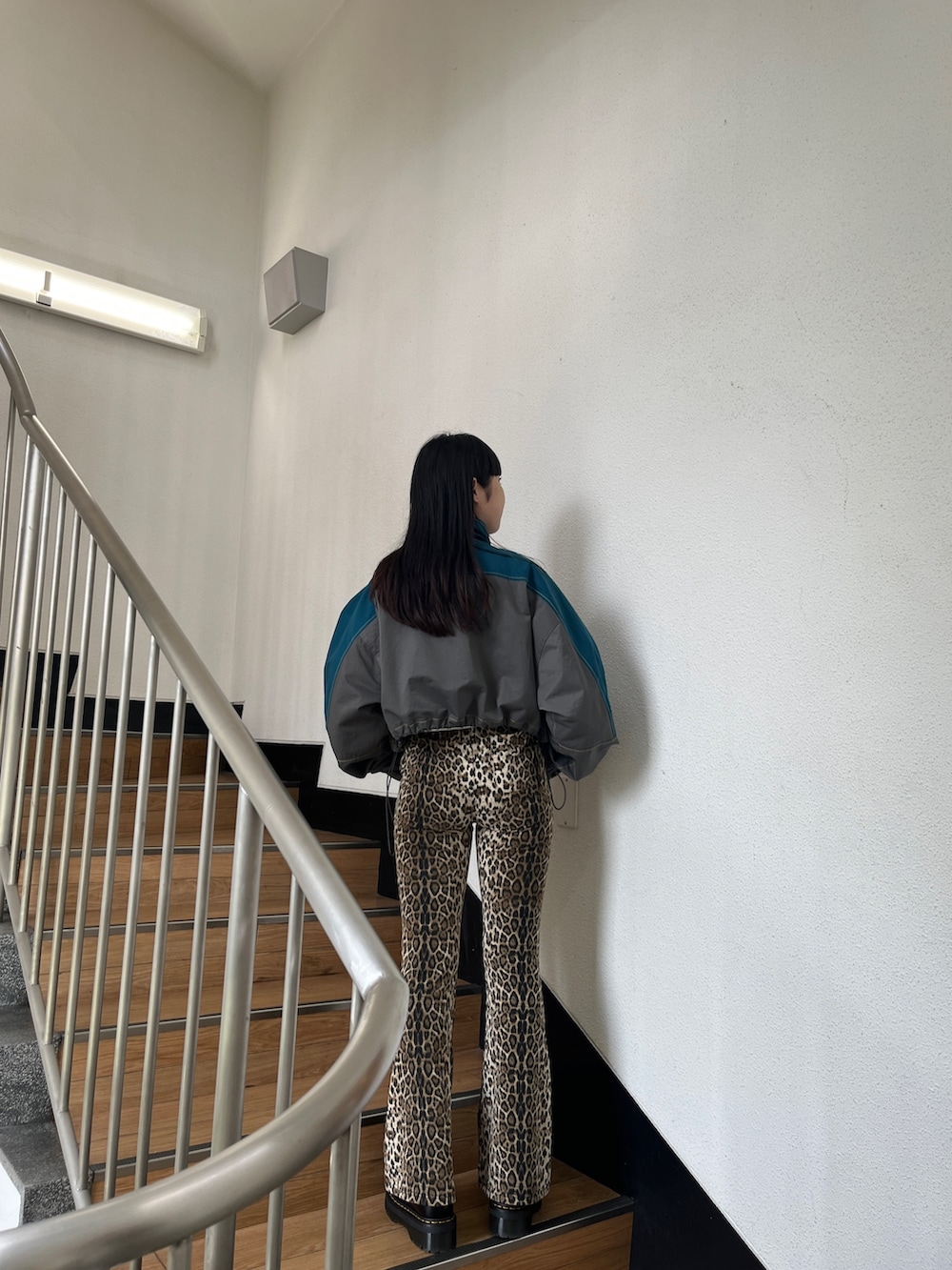 グリーン系のブルゾン、ブラウン系のその他パンツ、ホワイト系のタンクトップを着用したレディースの秋コーディネートの3枚目の写真