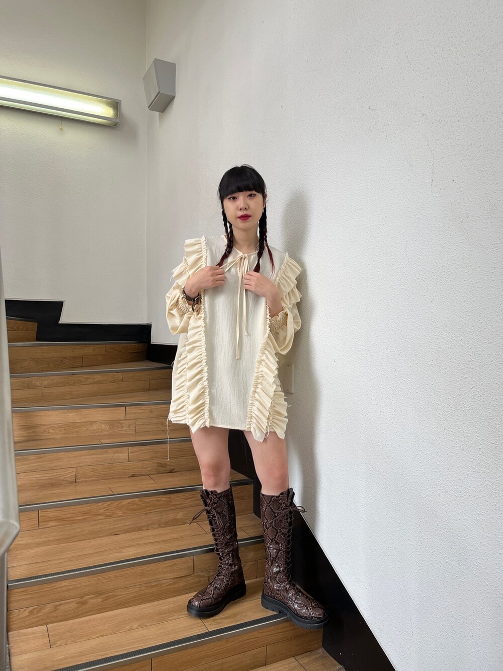 ブラック系のブーツ、ホワイト系のシャツ/ブラウス、ブラック系のデニムパンツを着用したレディースの冬コーディネートの2枚目の写真