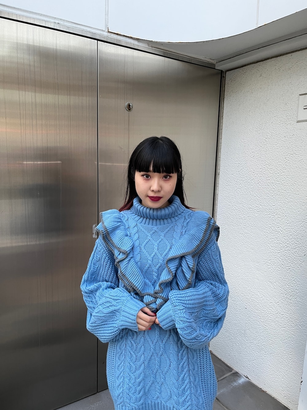 ブルー系のニット/セーター、ブラック系のブーツを着用したレディースの冬コーディネートの6枚目の写真