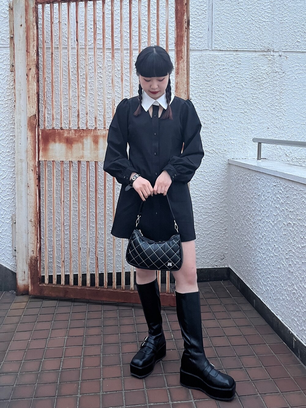 ブラック系のワンピース、ブラック系のブーツを着用したレディースの冬コーディネートの3枚目の写真