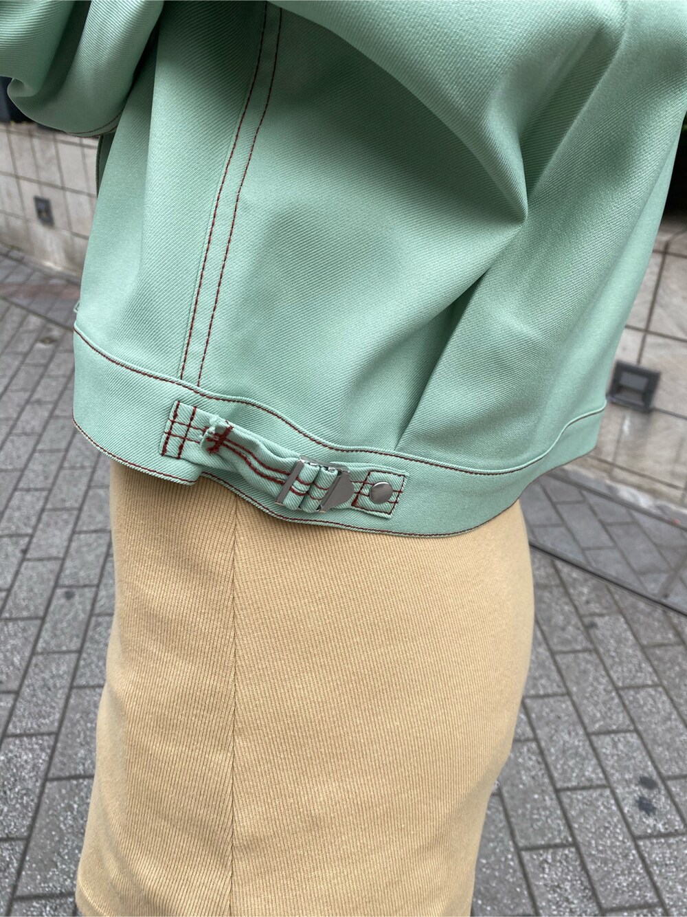 グリーン系のデニムジャケット、ベージュ系のチュニックを着用したレディースの春コーディネートの6枚目の写真