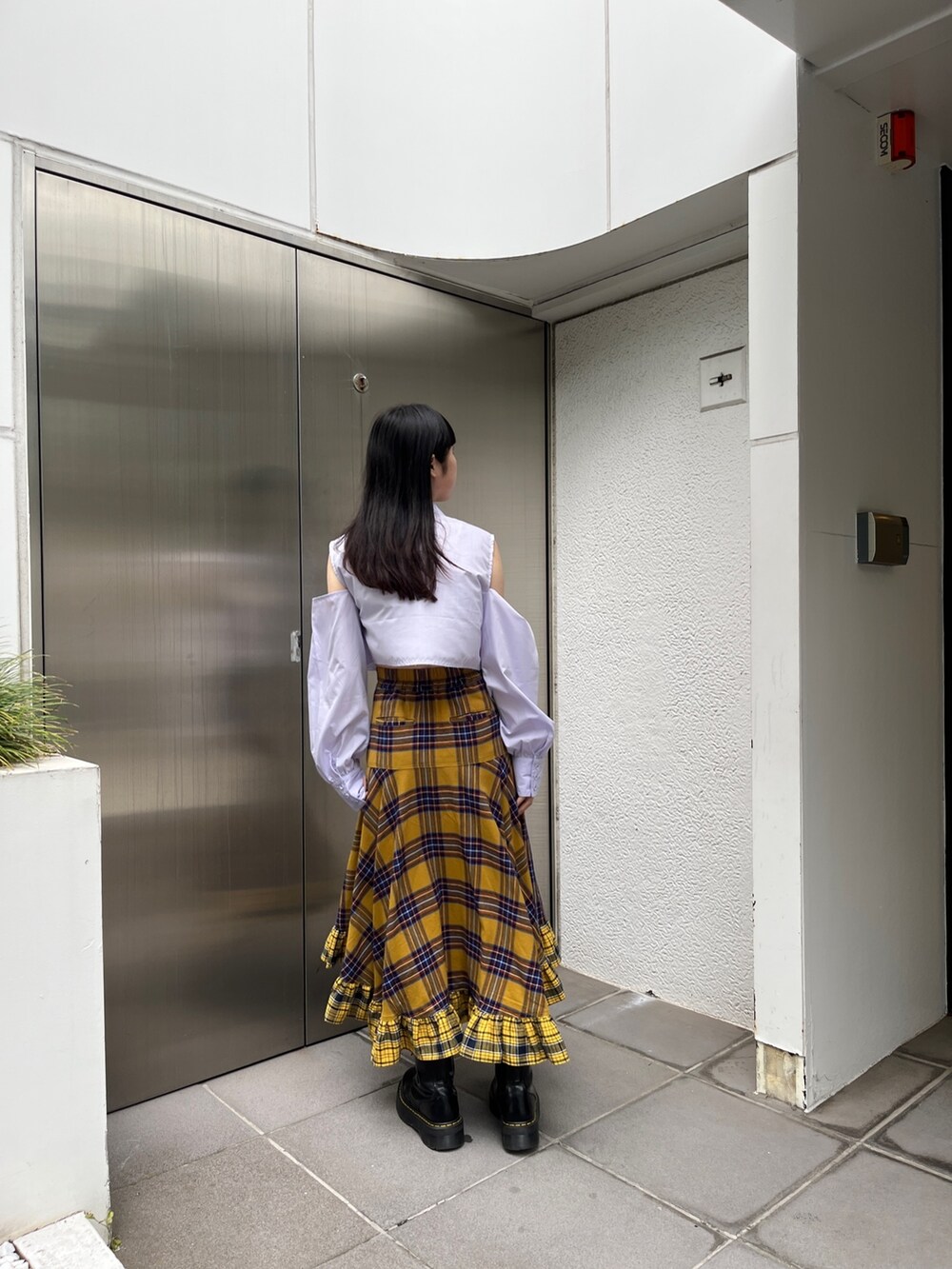 イエロー系のスカート、ブルー系のシャツ/ブラウス、ブラック系のその他シューズを着用したレディースの春コーディネートの3枚目の写真