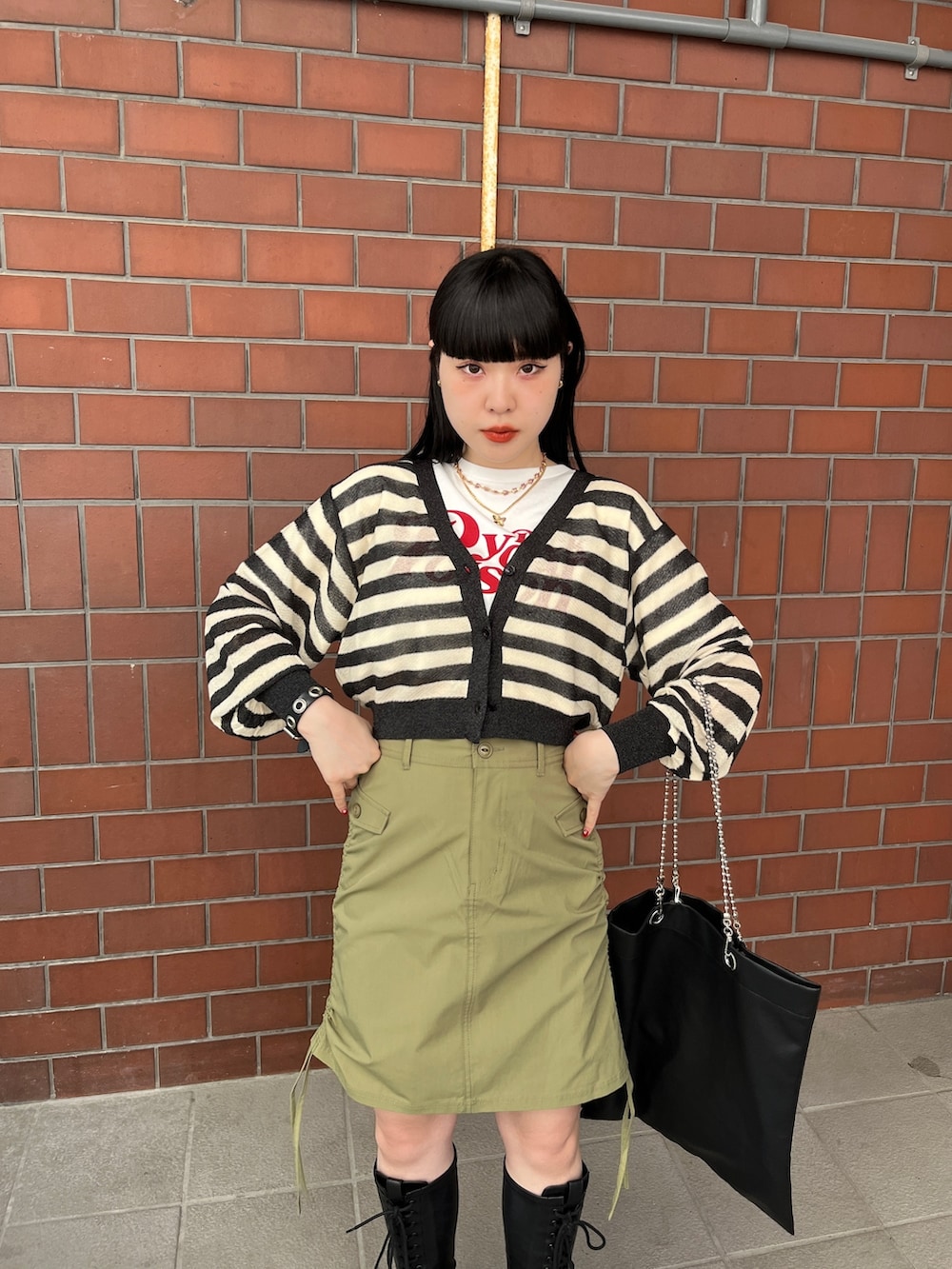 グリーン系のスカート、ブラック系のカーディガン/ボレロ、ホワイト系のTシャツ/カットソーを着用したレディースの夏コーディネートの8枚目の写真