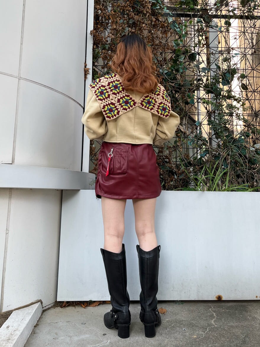 レッド系のスカート、ベージュ系のスウェットを着用したレディースの秋コーディネートの2枚目の写真