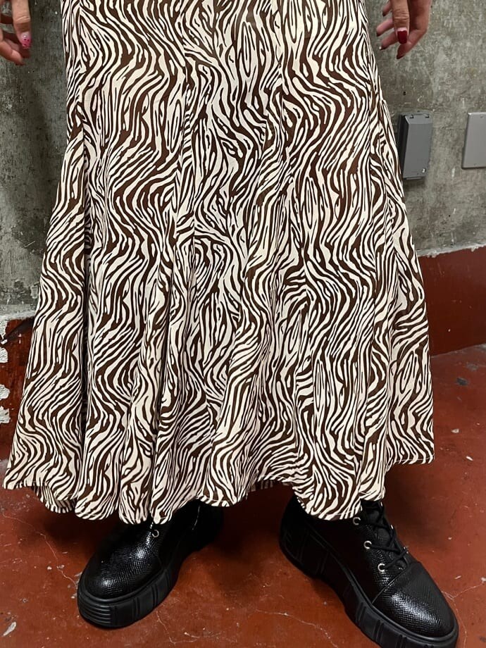 ブラック系のブーツ、ホワイト系のショルダーバッグ、その他のスカートを着用したレディースの春コーディネートの5枚目の写真