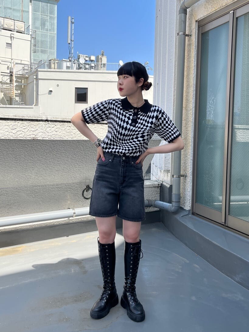 ブラック系のブーツ、ブラック系のニット/セーター、ブラック系のデニムパンツを着用したレディースの春コーディネートの2枚目の写真