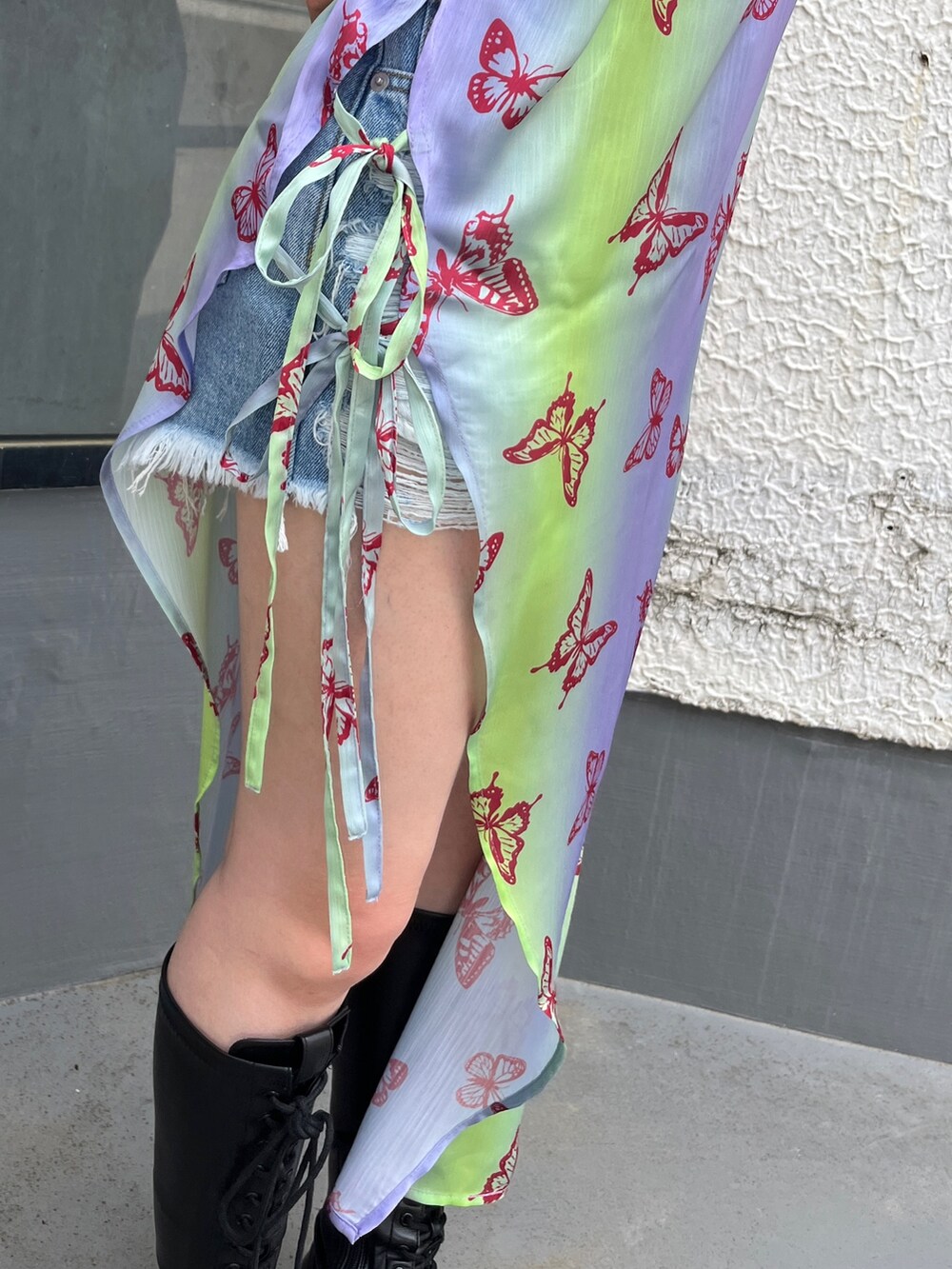 パープル系のワンピース、ブラック系のTシャツ/カットソー、ブラック系のブーツを着用したレディースの春コーディネートの7枚目の写真