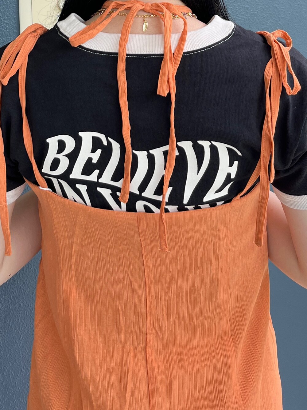 オレンジ系のワンピース、ホワイト系のTシャツ/カットソー、ブラック系のブーツを着用したレディースの夏コーディネートの8枚目の写真