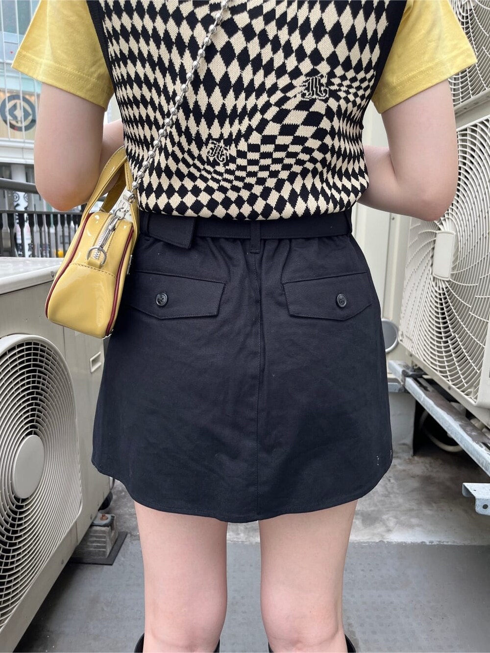 ブラック系のブーツ、ブラック系のニット/セーター、イエロー系のTシャツ/カットソーを着用したレディースの夏コーディネートの7枚目の写真