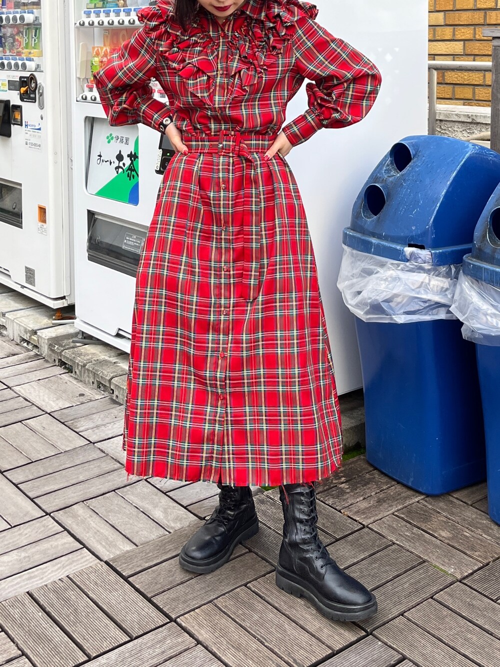 レッド系のワンピース、ブラック系のブーツを着用したレディースの冬コーディネートの2枚目の写真