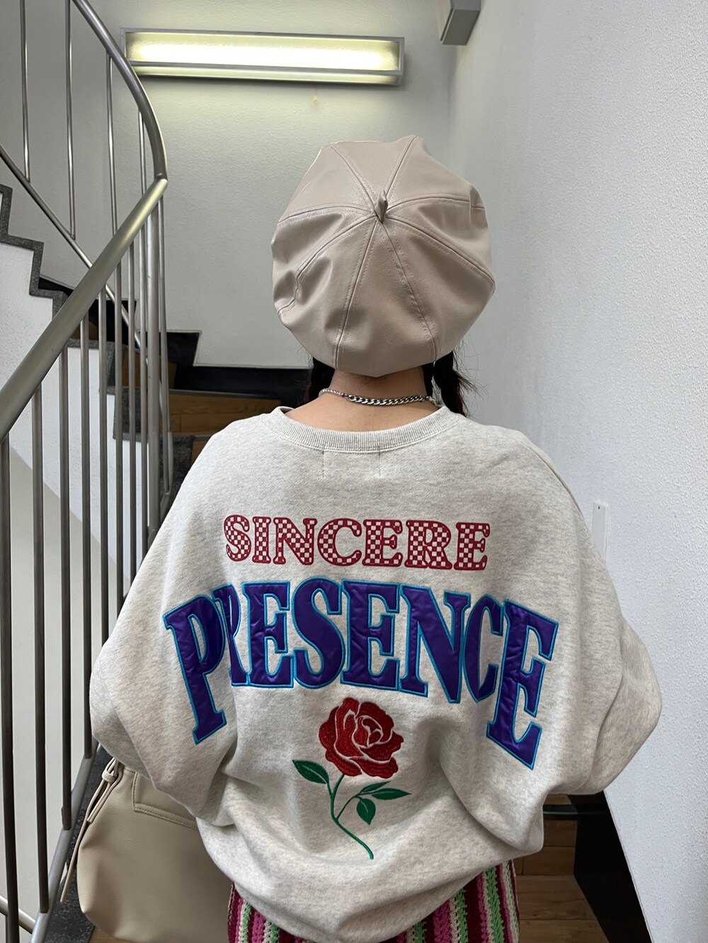 レッド系のスカート、グレー系のTシャツ/カットソー、ブラック系のブーツを着用したレディースの秋コーディネートの7枚目の写真