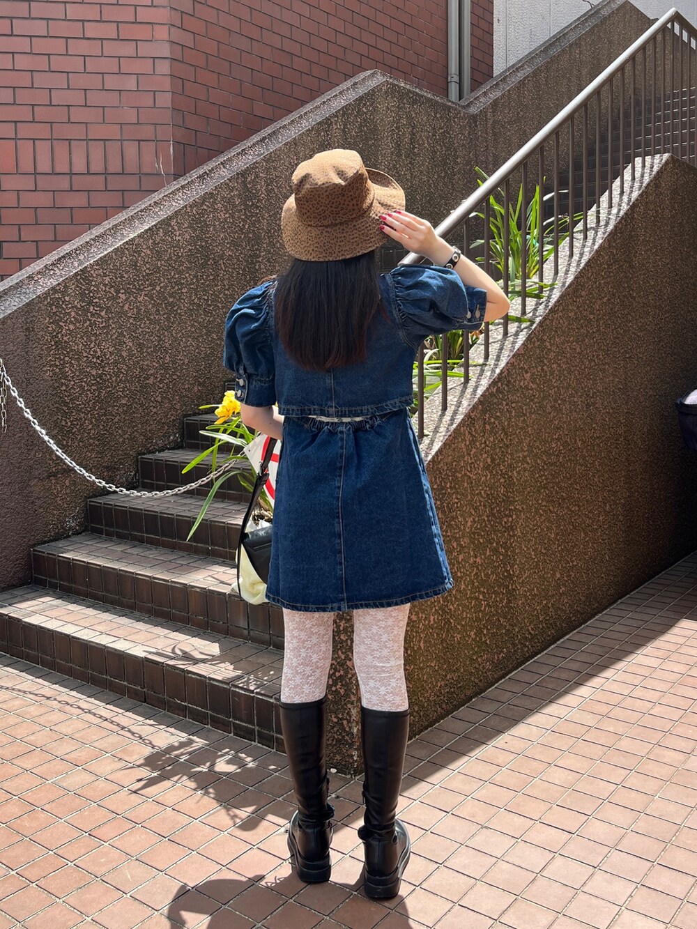 ホワイト系のショルダーバッグ、ブラック系のブーツ、ブルー系のワンピースを着用したレディースの春コーディネートの2枚目の写真