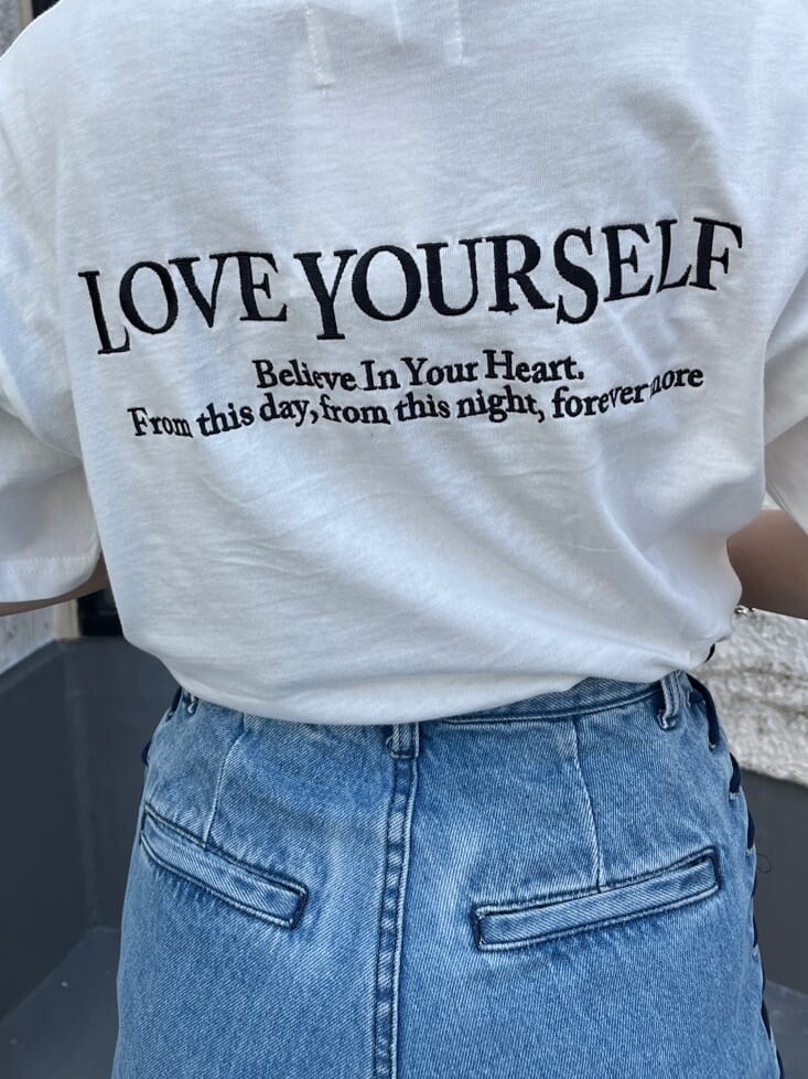 ブラック系のブーツ、ホワイト系のTシャツ/カットソー、ブルー系のデニムパンツを着用したレディースの春コーディネートの7枚目の写真