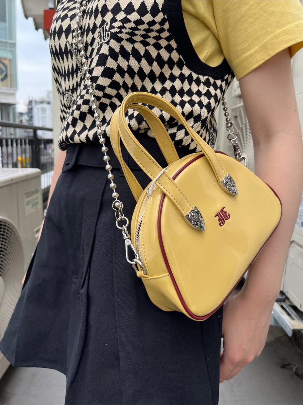 ブラック系のブーツ、ブラック系のニット/セーター、イエロー系のTシャツ/カットソーを着用したレディースの夏コーディネートの5枚目の写真