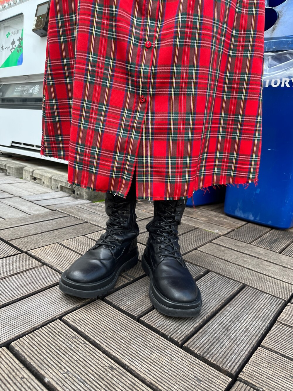 レッド系のワンピース、ブラック系のブーツを着用したレディースの冬コーディネートの6枚目の写真