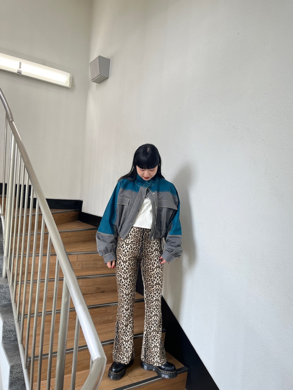 グリーン系のブルゾン、ブラウン系のその他パンツ、ホワイト系のタンクトップを着用したレディースの秋コーディネートの2枚目の写真