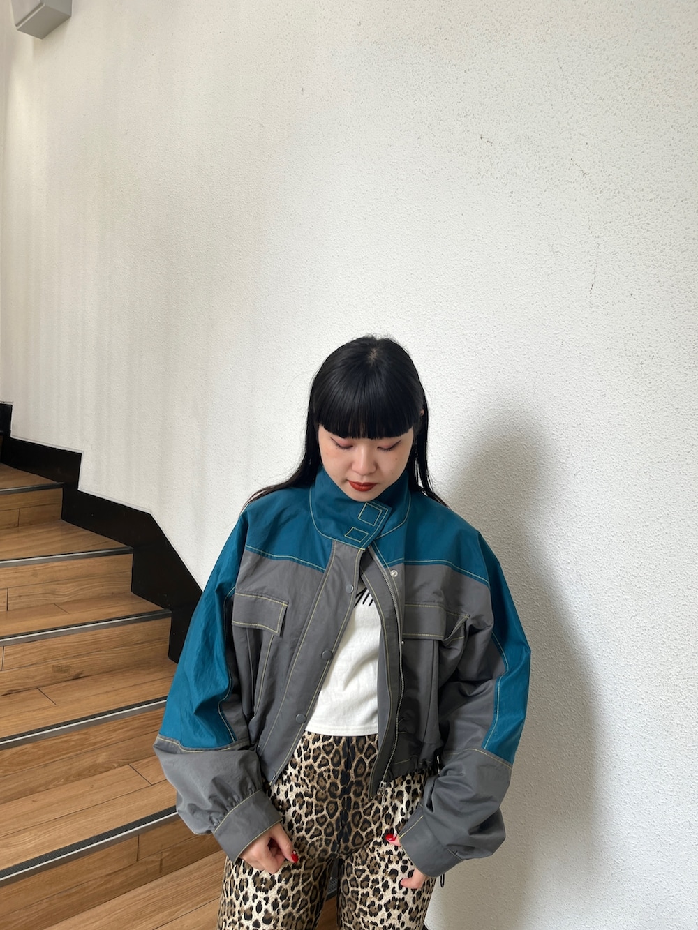 グリーン系のブルゾン、ブラウン系のその他パンツ、ホワイト系のタンクトップを着用したレディースの秋コーディネートの4枚目の写真