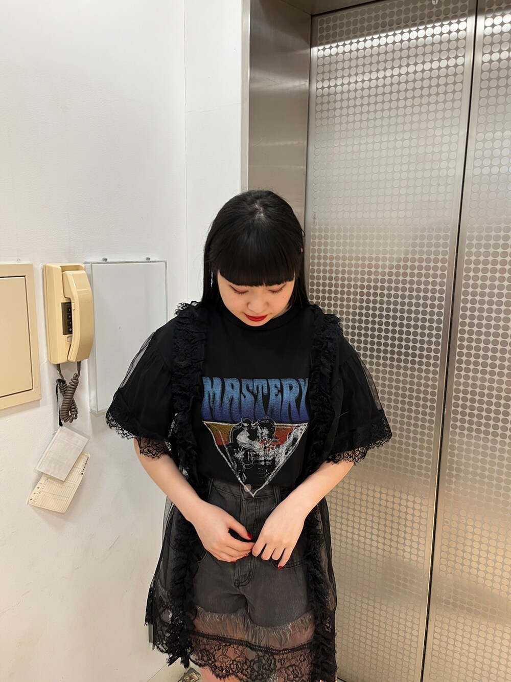 ブラック系のワンピース、ブラック系のブーツ、ブラック系のデニムパンツを着用したレディースの春コーディネートの5枚目の写真