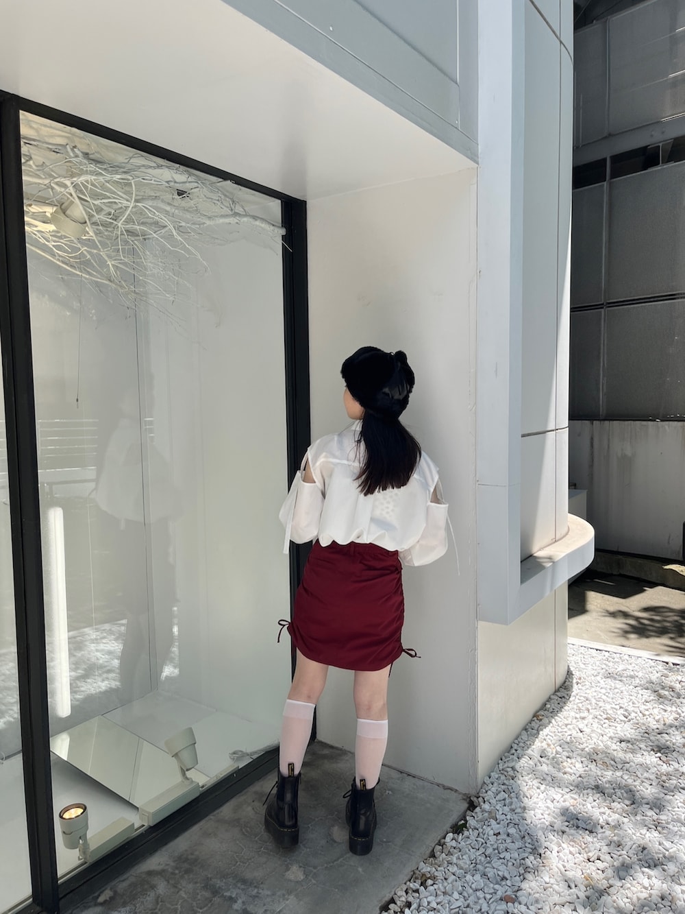 レッド系のスカート、ホワイト系のシャツ/ブラウス、ブラック系のキャップを着用したレディースの夏コーディネートの3枚目の写真