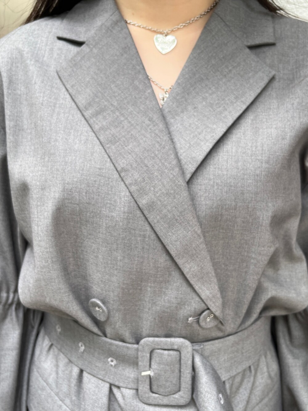 グレー系のワンピース、ブラック系のブーツ、シルバー系のネックレスを着用したレディースの夏コーディネートの6枚目の写真