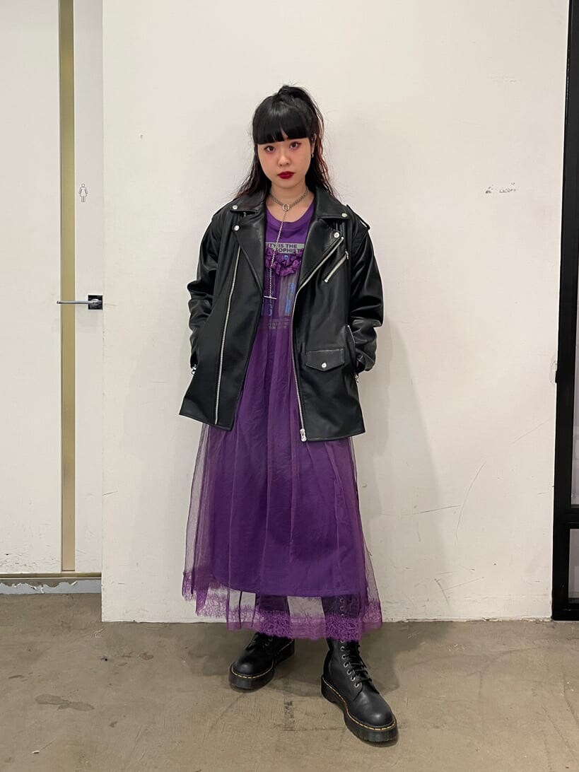 ブラック系のライダースジャケット、パープル系のワンピースを着用したレディースの秋コーディネートの2枚目の写真