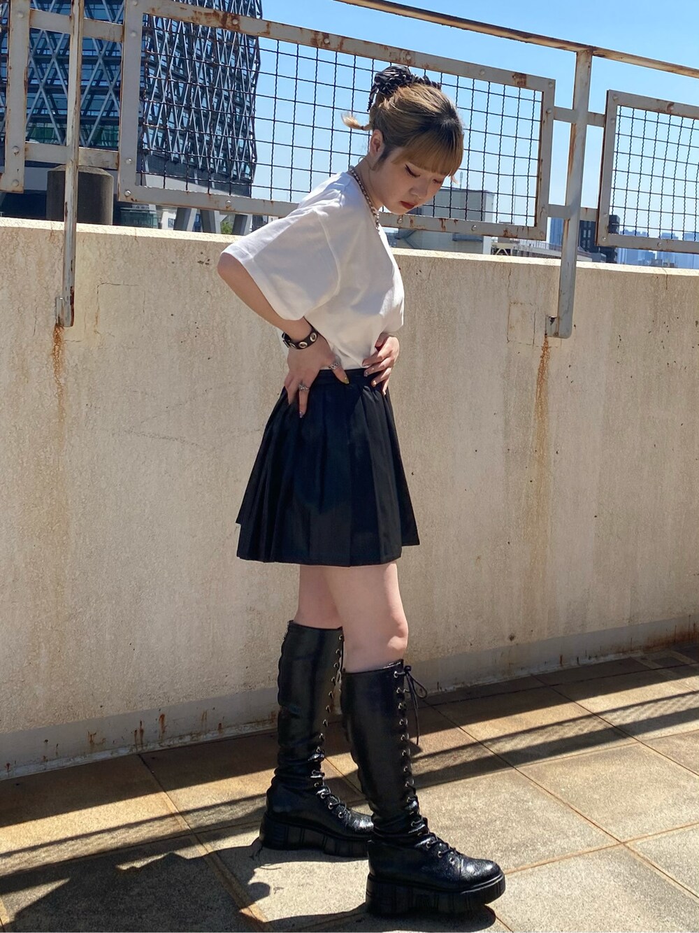 ブラック系のスカート、ホワイト系のTシャツ/カットソーを着用したレディースの春コーディネートの3枚目の写真