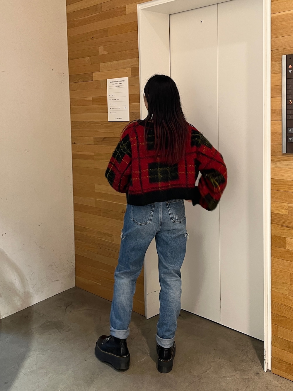 ブラック系のその他シューズ、レッド系のカーディガン/ボレロ、ブルー系のデニムパンツを着用したレディースの秋コーディネートの2枚目の写真