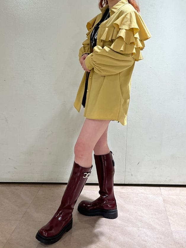 イエロー系のシャツ/ブラウス、レッド系のブーツ、ブラック系のデニムパンツを着用したレディースの冬コーディネートの3枚目の写真