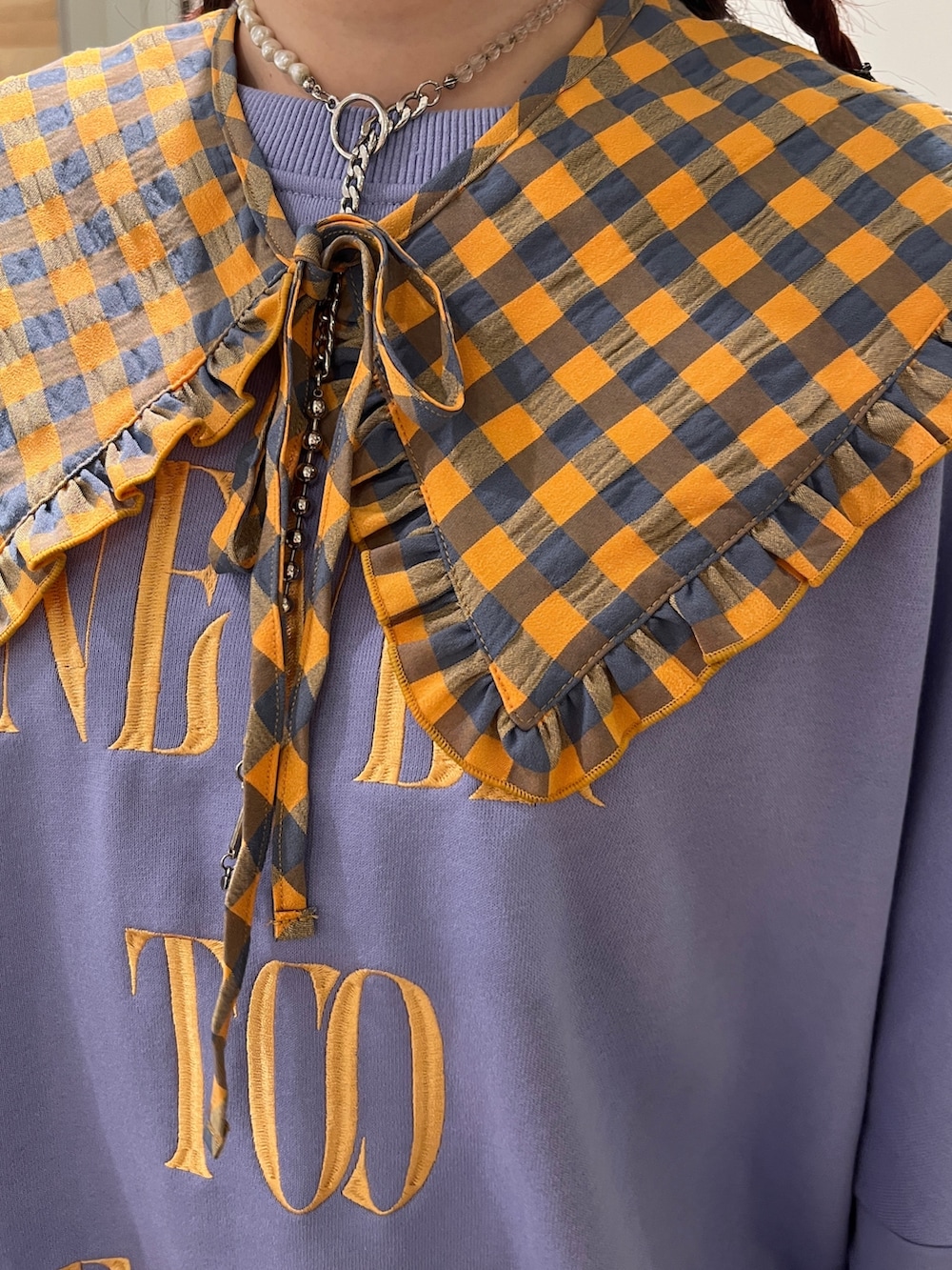 ブラック系のブーツ、パープル系のスウェット、ホワイト系のハンチング/ベレー帽を着用したレディースの秋コーディネートの5枚目の写真