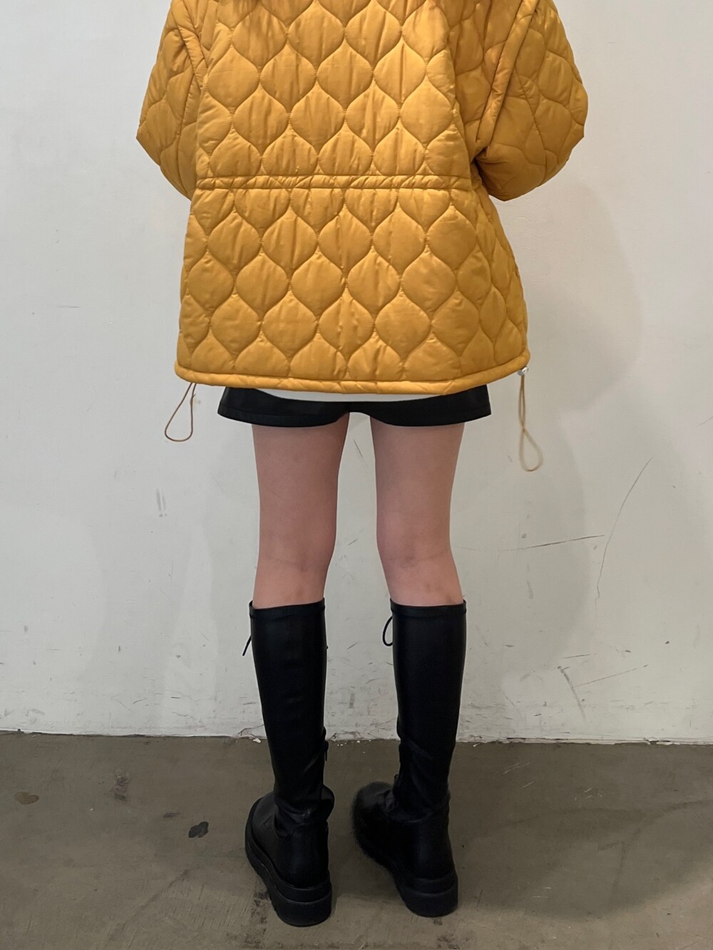 ブラック系のブーツ、グレー系のスウェット、イエロー系のその他アウターを着用したレディースの秋コーディネートの7枚目の写真