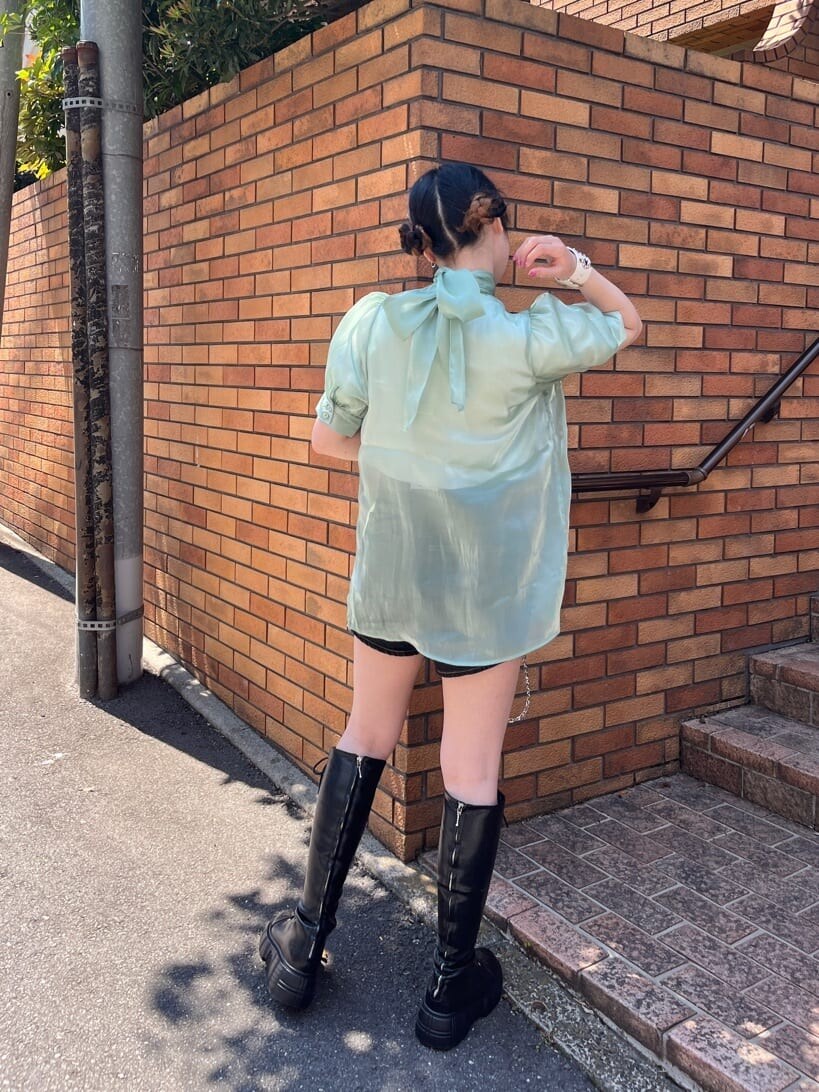 ブラック系のブーツ、ブラック系のデニムパンツ、グリーン系のシャツ/ブラウスを着用したレディースの春コーディネートの4枚目の写真