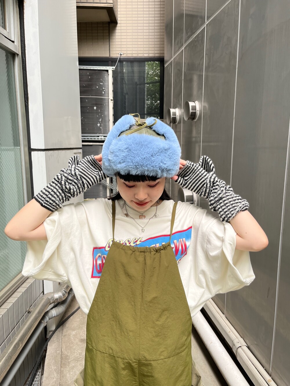 ホワイト系のTシャツ/カットソー、ブラック系のブーツ、ブラック系のアームカバーを着用したレディースの夏コーディネートの4枚目の写真