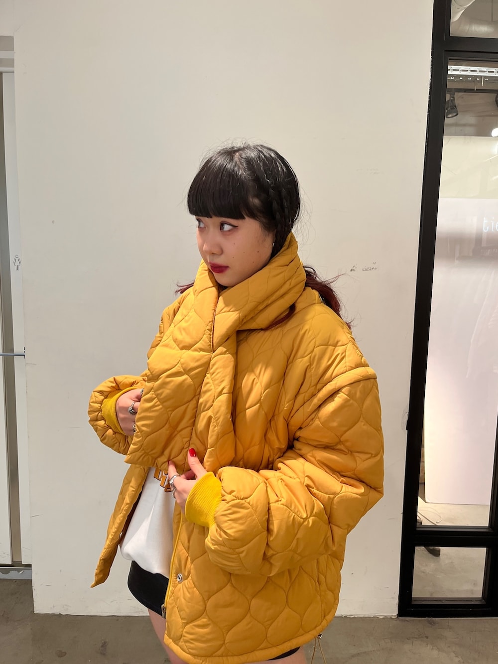 ブラック系のブーツ、グレー系のスウェット、イエロー系のその他アウターを着用したレディースの秋コーディネートの3枚目の写真