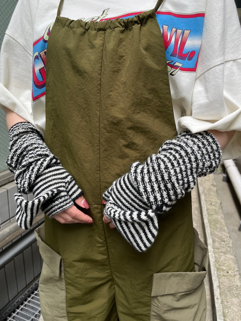 ホワイト系のTシャツ/カットソー、ブラック系のブーツ、ブラック系のアームカバーを着用したレディースの夏コーディネートの6枚目の写真