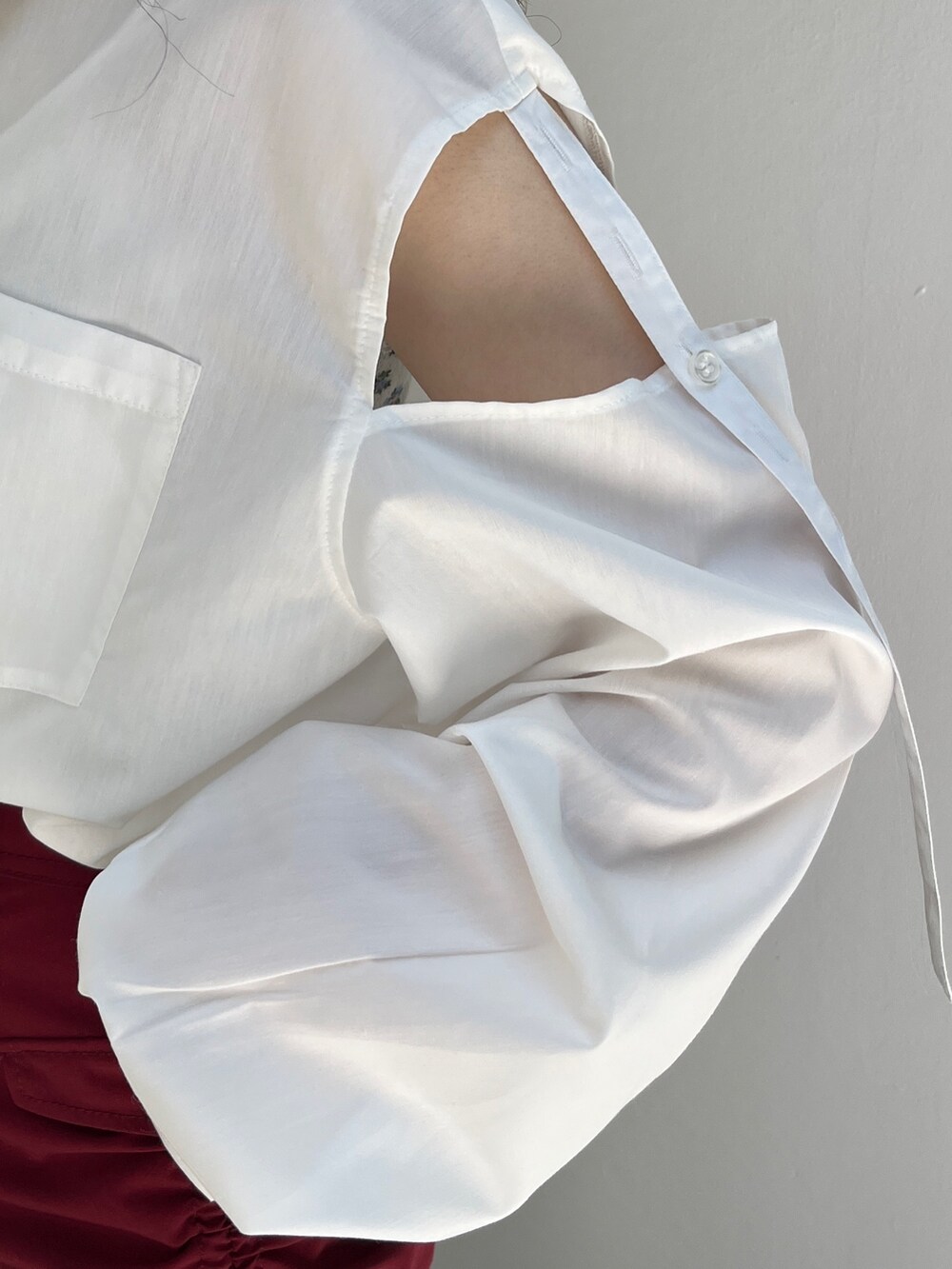 レッド系のスカート、ホワイト系のシャツ/ブラウス、ブラック系のキャップを着用したレディースの夏コーディネートの6枚目の写真